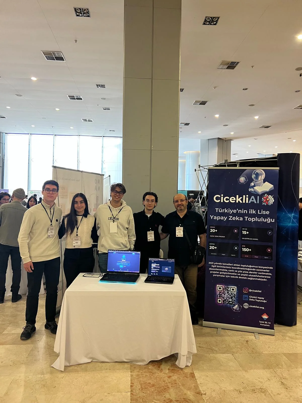 ÇiçekliAI members beside the community's exhibition stand and project laptops